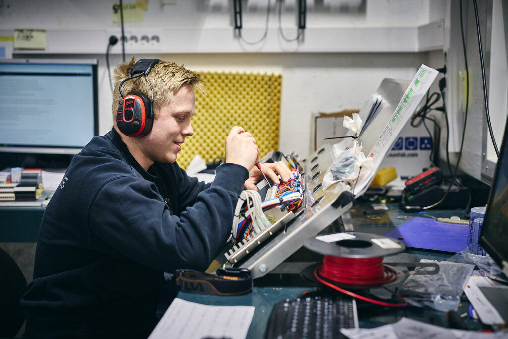 Smilende lærling hos Nomek som jobber med automasjon og miljøpåbygg