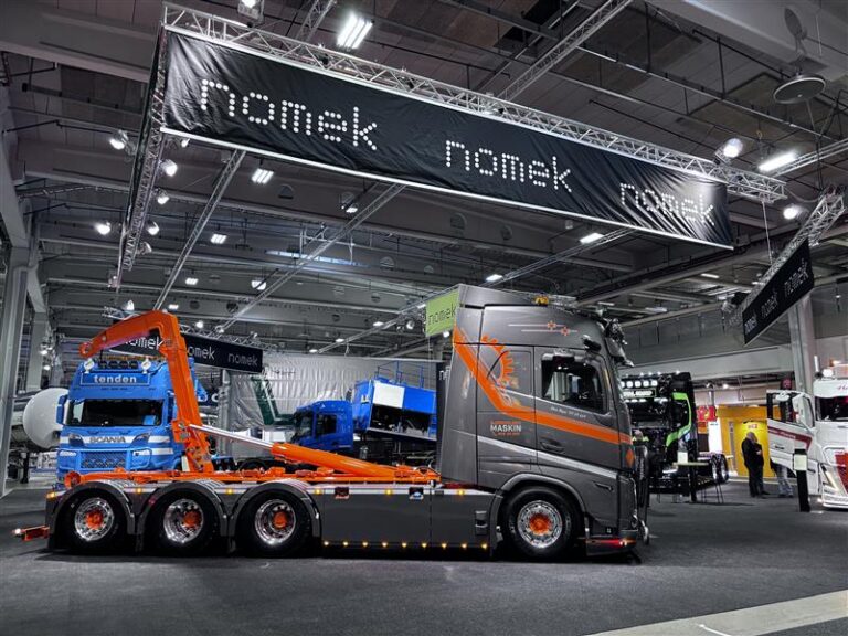 Krokbil fra Nomek for Bjørnvolden Maskin presentert på Transport 2026, med flere personer samlet foran bilen på messen.